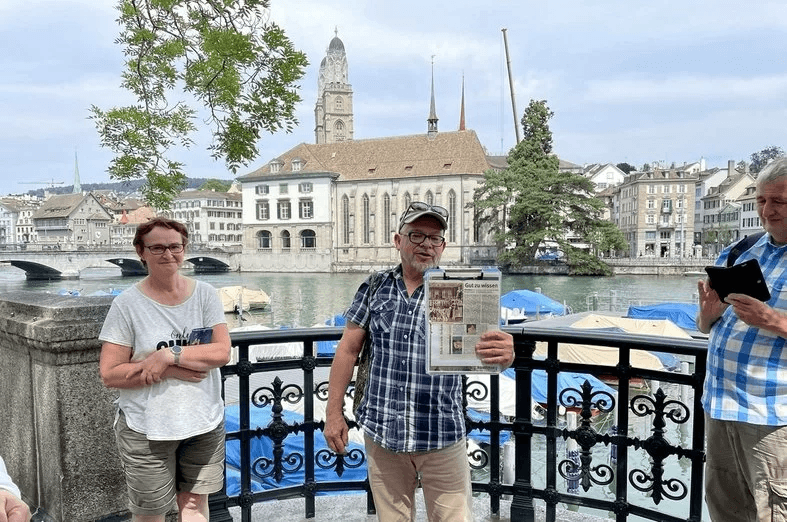 Zurich Old Town: guided tour with participants in front of the Water Cross and charming buildings.