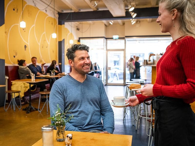 Basel Foodtour Bakery Kult: Guest receives coffee in cozy café