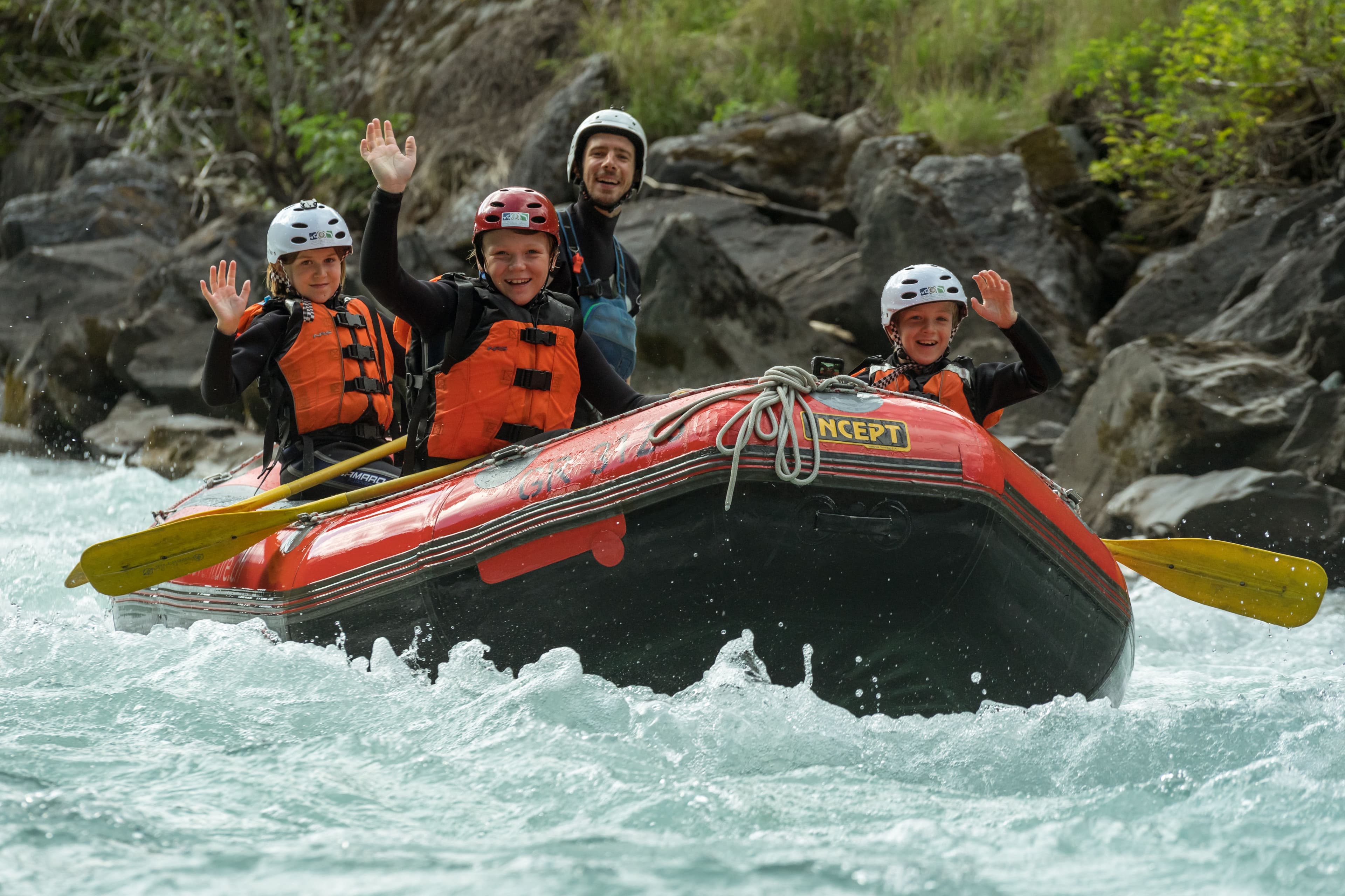 Rafting in Engadin with a family in a red boat