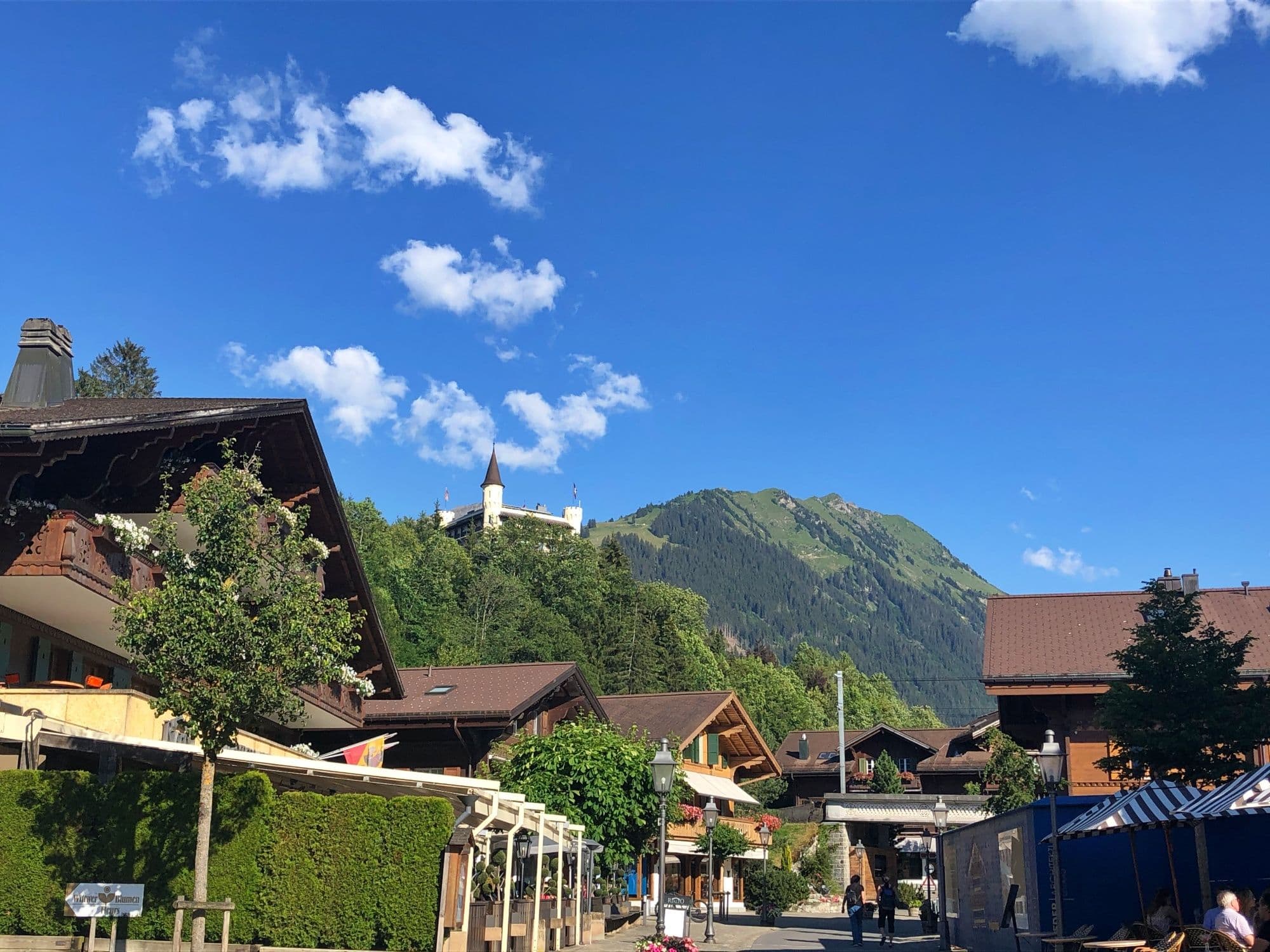 Geneva transfer to Gstaad with a view of the mountains, traditional chalets, and blue sky