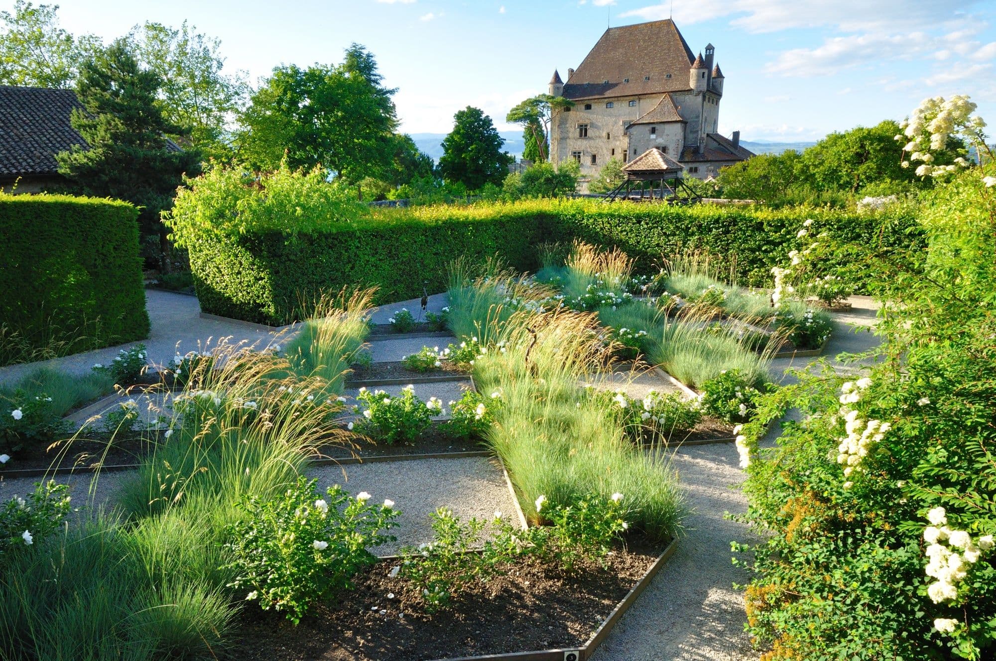 The Garden of the Five Senses with well-tended garden and view of the Château d'Yvoire.