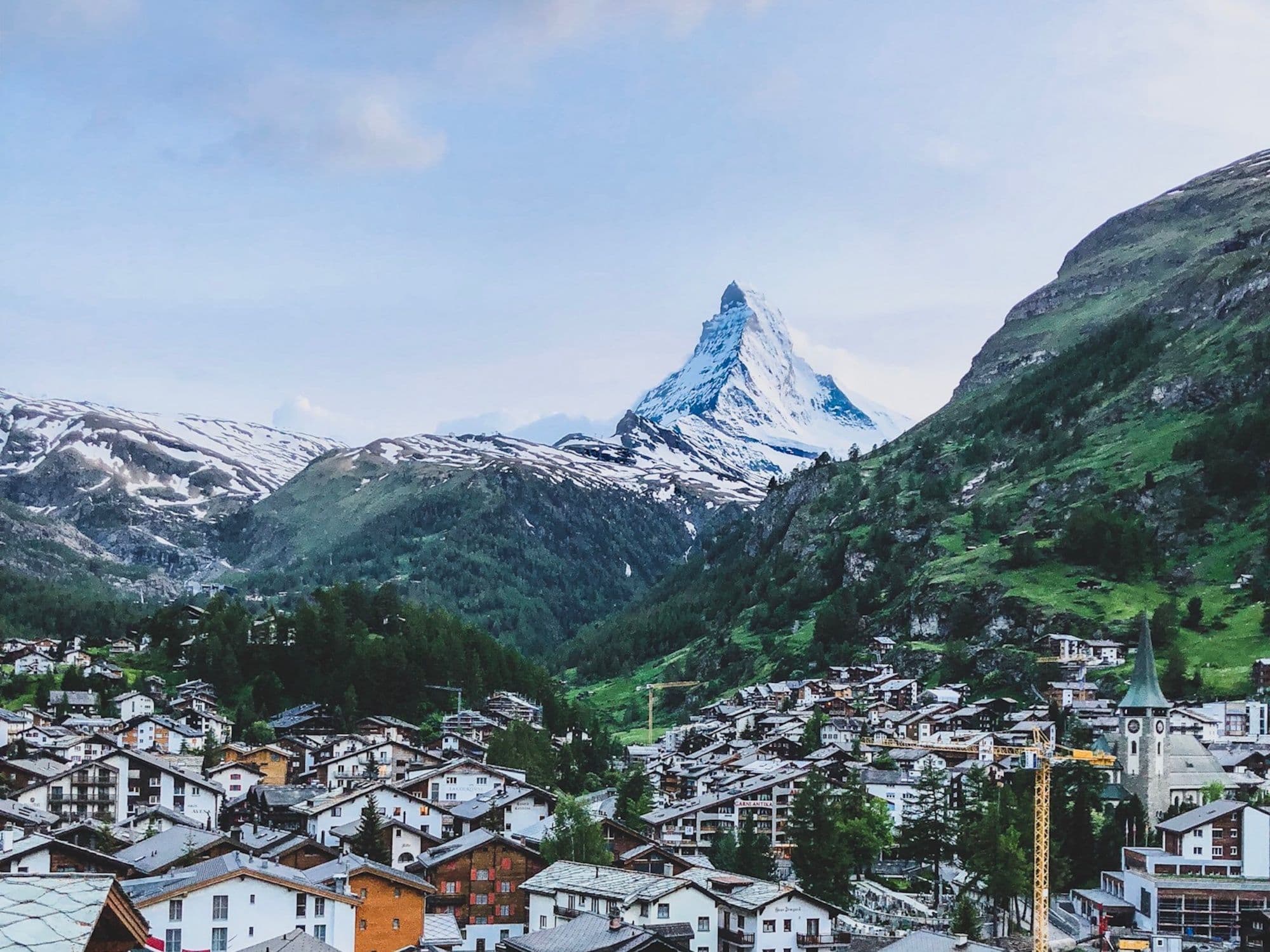 Transfer from Geneva to Zermatt with a view of the Matterhorn, surrounding mountains, and alpine architecture.