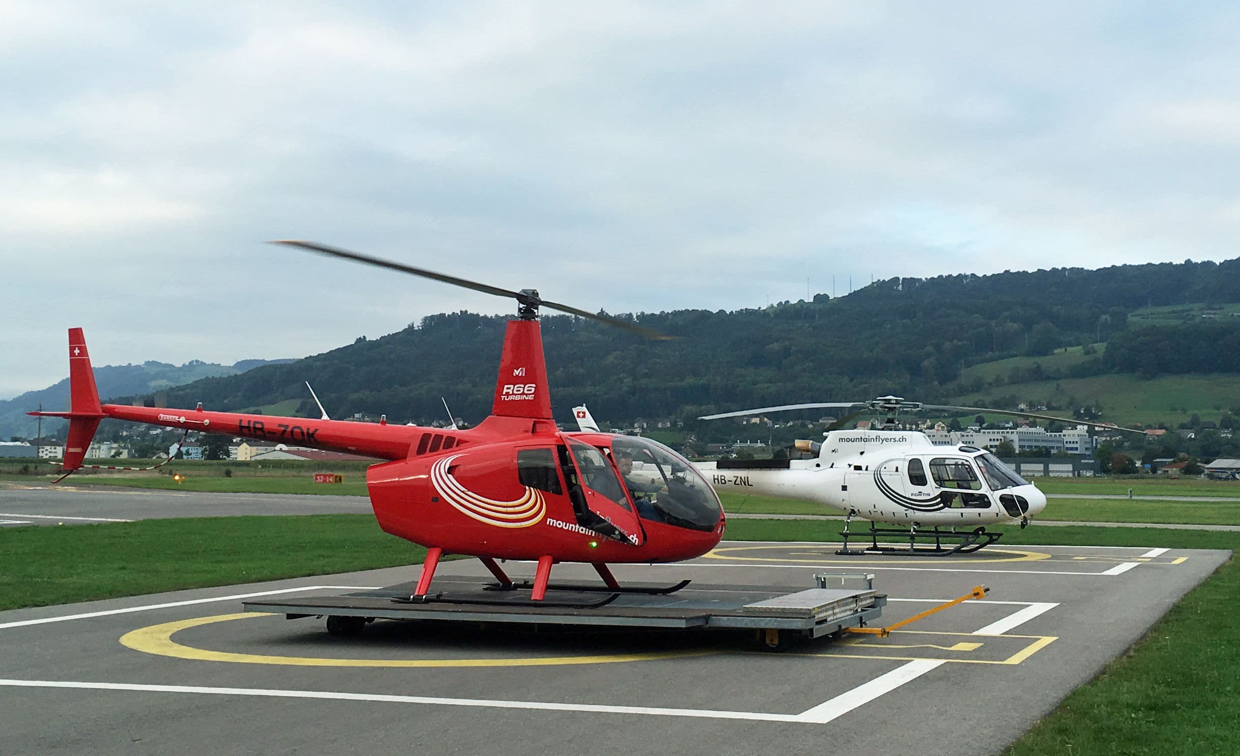 Helicopter sightseeing flight in Bern with two helicopters at the airfield