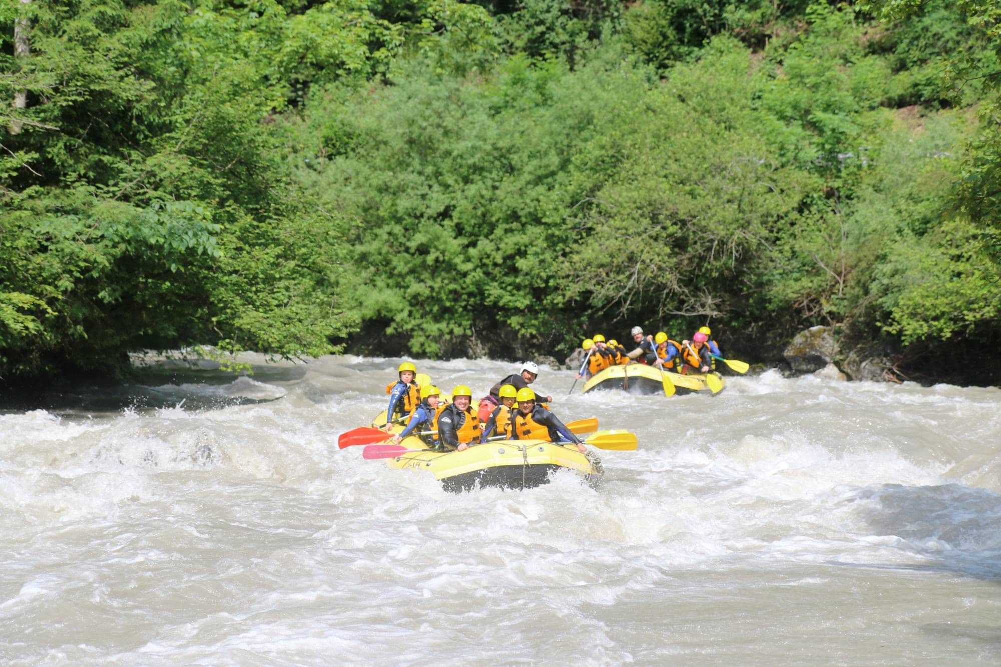 Rafting Simme with participants in yellow vests in the white water
