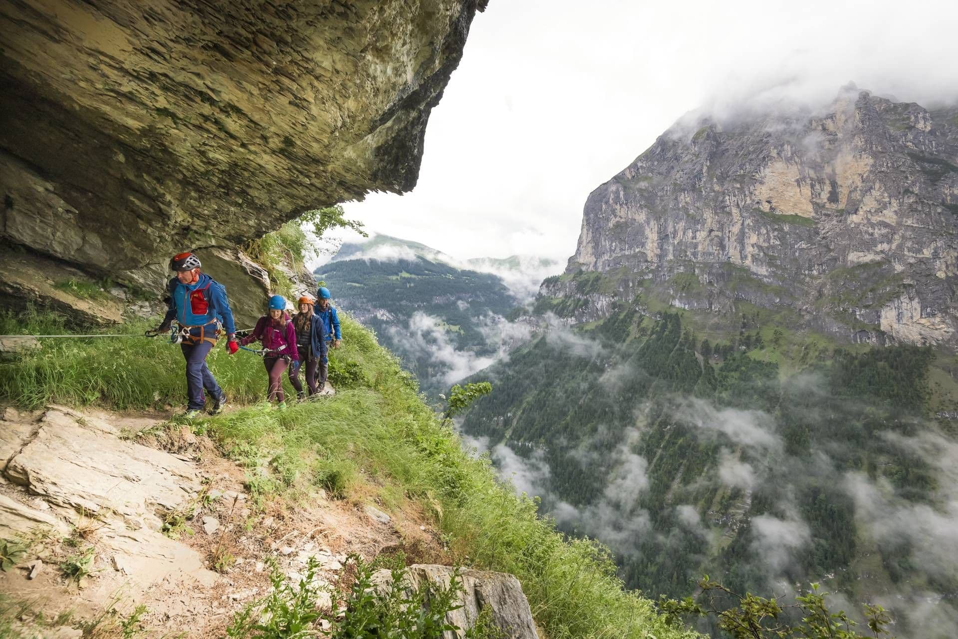 Mürren Via Ferrata views, climber on the rock, mountain landscape, clouds