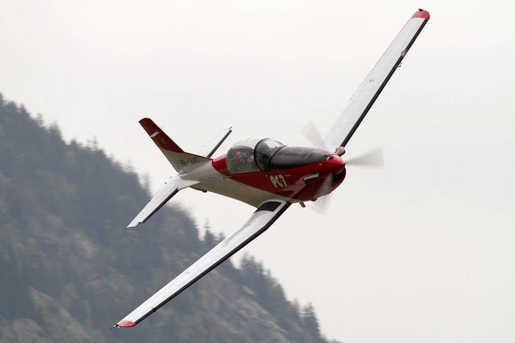 Pilatus PC-7 in high-speed flight over mountains, clear visibility, spring 2023.