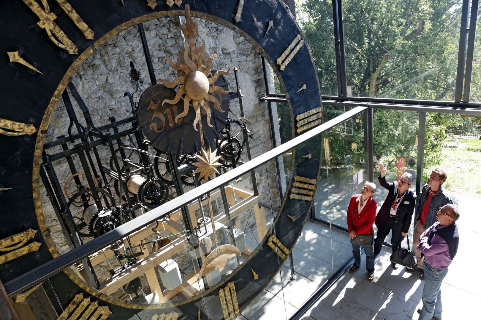 Musegg Wall Lucerne, visitors viewing historical clock mechanism, city tour with informative details.