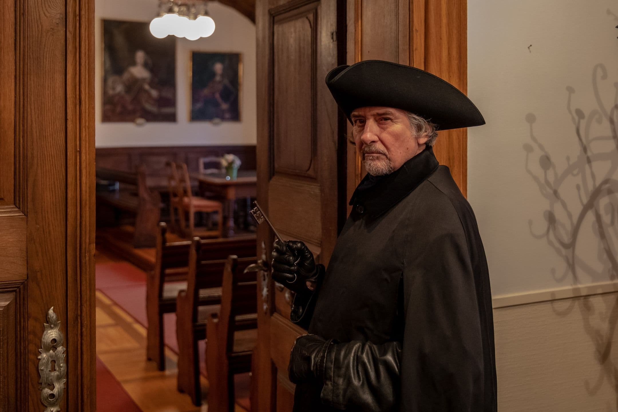 Night watchman in Rheinfelden Town Hall, elegantly dressed, the surroundings brightly lit.